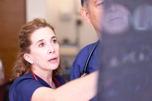 doctor reviewing an X-ray on a light box with a patient