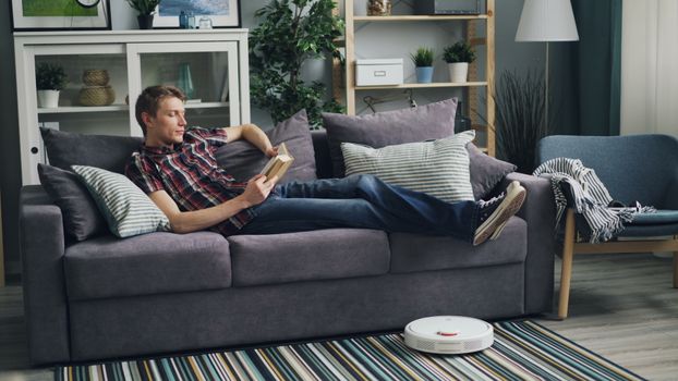 Roombas and automated robot vacuums lined up on charging docks in a modern living room