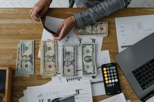 A piggy bank sitting on a desk next to a stack of coins.