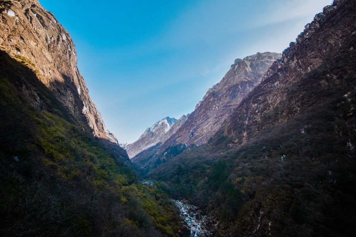 Stunning view of Deurali valley in the Himalayas, showcasing rugged landscapes and blue skies.