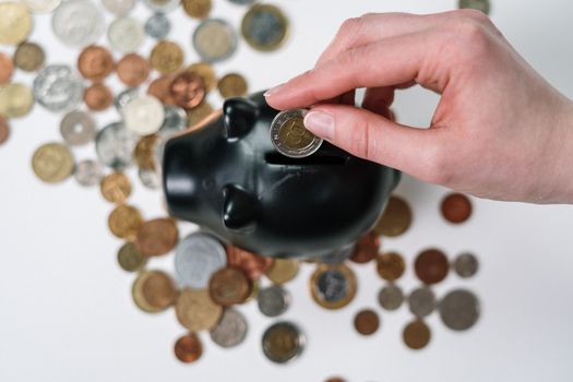 A piggy bank on a stack of coins next to a calculator