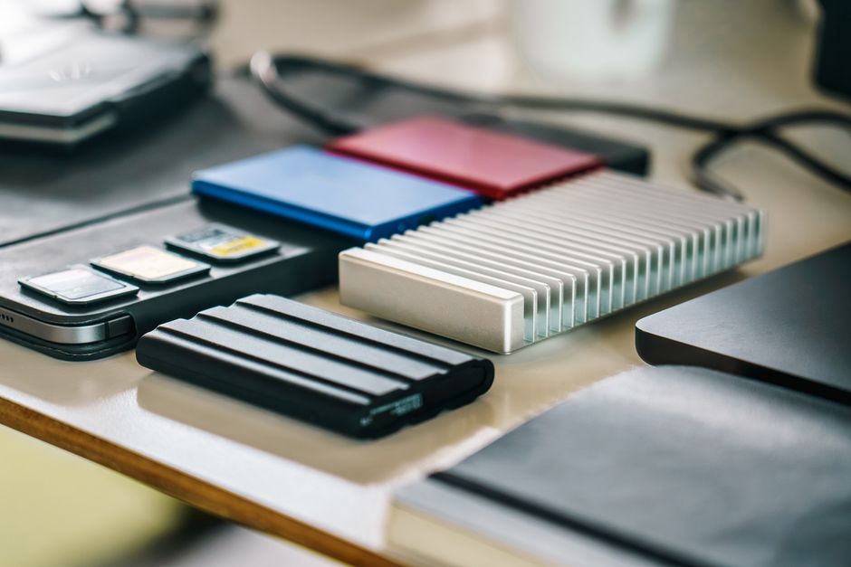 Close-up of desk with SSDs, memory cards, and modern tech gadgets for content creation.