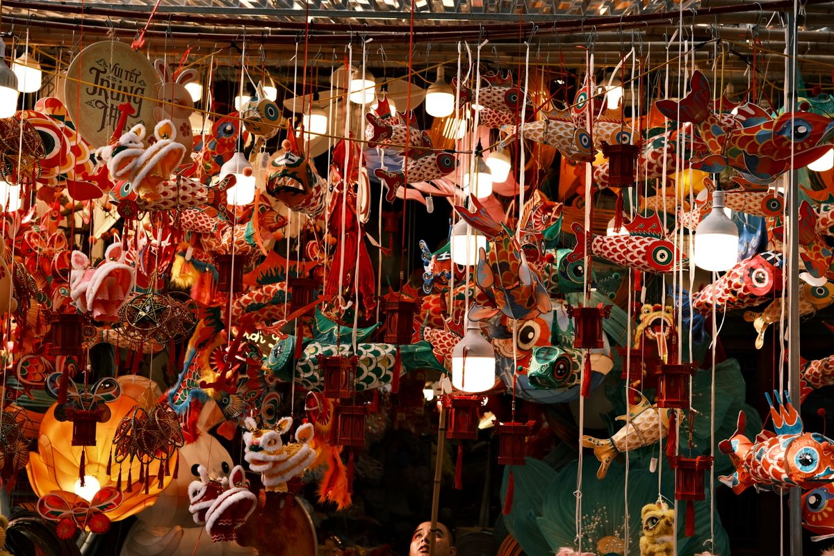 Colorful lanterns and decorations hang tightly in a bustling market for the Mid-Autumn Festival.
