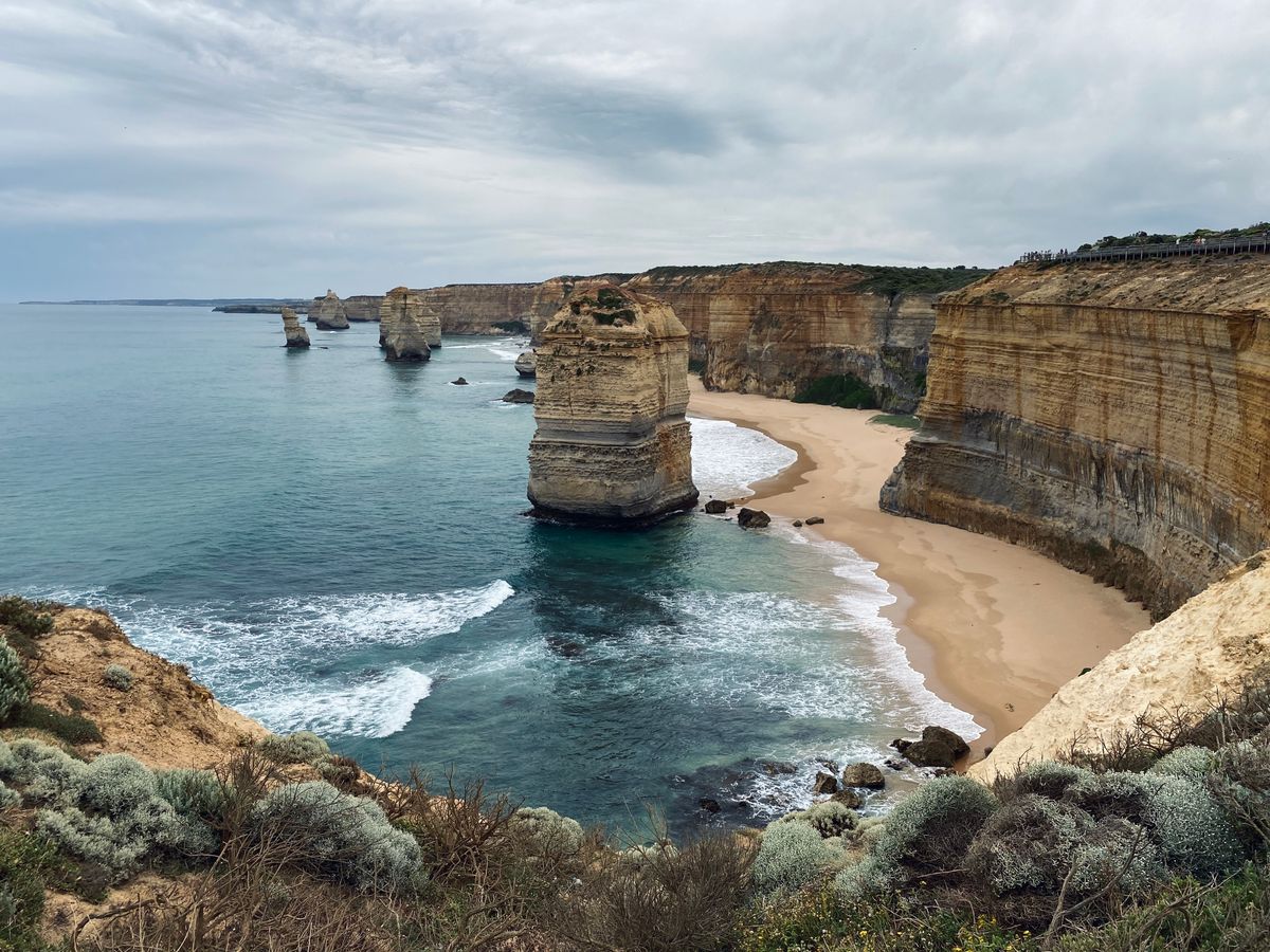 Stunning view of the Twelve Apostles with towering cliffs and waves crashing on the shore.
