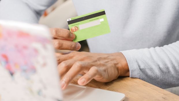 Close up of a person holding a credit card while looking at a stadium on a smartphone
