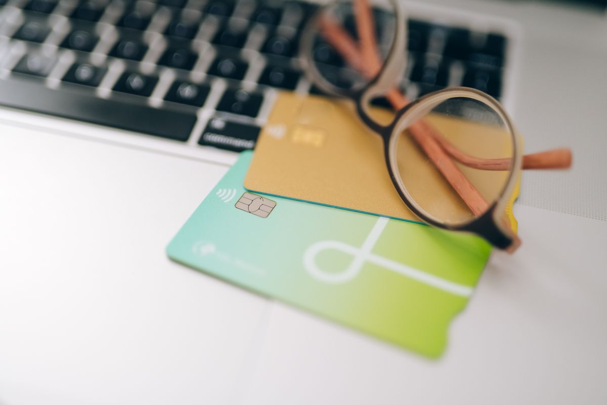 Premium metal credit card resting on a wooden desk next to a passport